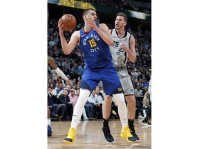 Denver Nuggets center Nikola Jokic (15) is pressured by San Antonio Spurs center Jakob Poeltl (25) in the first half of Game 5 of an NBA basketball first-round playoff series Tuesday, April 23, 2019, in Denver.