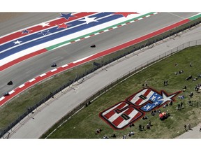 Fans sit near a tribute to Nicky Hayden as they watch a practice session for the Grand Prix of the Americas motorcycle race at the Circuit Of The Americas, Friday, April 12, 2019, in Austin, Texas. MotoGP has retired Hayden's No. 69.