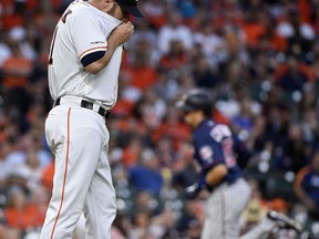 Houston Astros starting pitcher Brad Peacock, left, walks off the mound as Minnesota Twins' Jason Castro, back right, rounds the bases after hitting a solo home run during the second inning of a baseball game, Monday, April 22, 2019, in Houston.