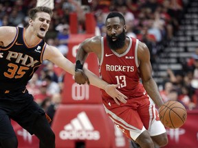 Houston Rockets guard James Harden (13) drives around Phoenix Suns forward Dragan Bender (35) during the second half of an NBA basketball game Sunday, April 7, 2019, in Houston.