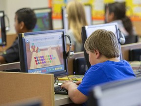 FILE - In this Oct. 29, 2018 file photo, students work on computers at an elementary school in Beaver, Utah. According to a study published on Tuesday, April 23, 2019, Americans are becoming increasingly sedentary, spending almost a third of their waking hours sitting down, and computer use is partly to blame.