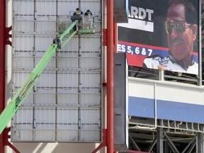 With a banner of former NASCAR driver Dale Earnhardt at upper right, workers perform maintenance on the illuminated signage on the Tower E elevator, Monday, April 1, 2019, in Bristol, Tenn. A full schedule of racing is coming up this weekend with the Bush's Beans Pole Day on Friday, the Alsco Xfinity Race 300 on Saturday, and the Monster Energy NASCAR Cup Food City 500 on Sunday.
