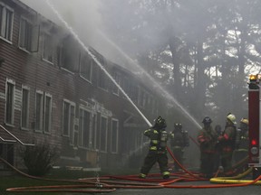 Shaftsbury and North Bennington firefighters hose down a blaze at "the Barn", a two-story building that contains classrooms and the college administrative offices, at Bennington College in Bennington, Vt., Tuesday, April 30, 2019.