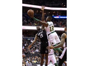 Boston Celtics guard Terry Rozier (12) goes to the basket against Washington Wizards center Ian Mahinmi (28) during the first half of an NBA basketball game Tuesday, April 9, 2019, in Washington.