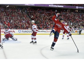 Washington Capitals right wing T.J. Oshie, right, celebrates his goal against Carolina Hurricanes goaltender Petr Mrazek (34), of the Czech Republic, and center Sebastian Aho (20), of Finland, during the first period of Game 2 of an NHL hockey first-round playoff series, Saturday, April 13, 2019, in Washington. The Capitals won 4-3 in overtime.