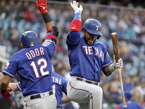 Texas Rangers' Elvis Andrus, right, congratulates Rougned Odor (12) after Odor's three-run home run against the Seattle Mariners in the second inning of a baseball game, Saturday, April 27, 2019, in Seattle.