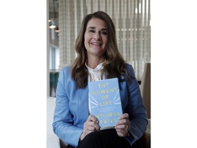 In this photo taken Thursday, April 18, 2019, Melinda Gates poses for a photo with her new book, "The Moment of Lift," in Kirkland, Wash. Her new book is a memoir from the former Microsoft tech business executive, outspoken feminist and public supporter of the MeToo movement. The Associated Press reviewed an advanced copy of the book ahead of its release Tuesday.