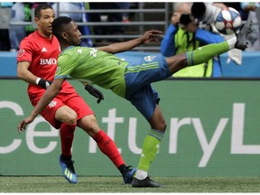 Seattle Sounders defender Kelvin Leerdam, right, kicks the ball away from Toronto FC defender Justin Morrow, left, during the first half of an MLS soccer match, Saturday, April 13, 2019, in Seattle.