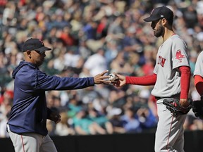 Boston Red Sox starting pitcher Rick Porcello, right, is pulled by manager Alex Cora, left, during the first inning of a baseball game against the Seattle Mariners, Sunday, March 31, 2019, in Seattle.