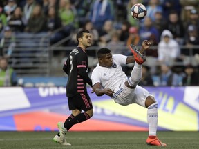 San Jose Earthquakes defender Harold Cummings, right, makes a defensive bicycle kick to clear the ball away from Seattle Sounders midfielder Victor Rodriguez, left, during the first half of an MLS soccer match, Wednesday, April 24, 2019, in Seattle.