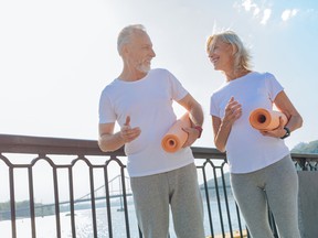 Lovely senior couple walking with yoga mats