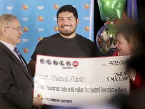 Manuel Franco of West Allis, Wis., winner of second-highest Powerball lottery in history, attends a news conference at the Wisconsin Department of Revenue in Madison, Wis., on Tuesday, April 23, 2019. At right is Peter Barca, state secretary of revenue, and at right is Cindy Polzin, state lottery director. Franco claimed the cash option payout of the prize, totaling approximately $477 million before taxes. The overall jackpot of the prize, drawn March 22, was $768,400.