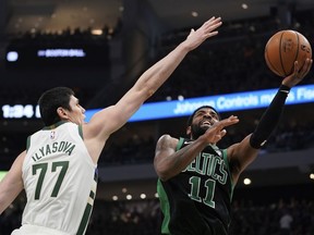 Boston Celtics' Kyrie Irving shoots past Milwaukee Bucks' Ersan Ilyasova during the second half of Game 1 of a second round NBA basketball playoff series Sunday, April 28, 2019, in Milwaukee. The Celtics won 112-90 to take a 1-0 lead in the series.