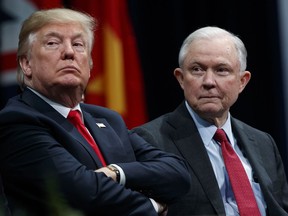 FILE - In this Dec. 15, 2017 file photo, President Donald Trump sits with Attorney General Jeff Sessions during the FBI National Academy graduation ceremony in Quantico, Va.