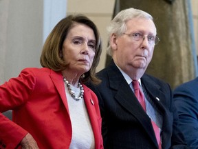 FILE - In this March 21, 2018, file photo Nancy Pelosi of Calif.,  and Senate Majority Leader Mitch McConnell of Ky., attend a Congressional Gold Medal Ceremony honoring the Office of Strategic Services in Emancipation Hall on Capitol Hill in Washington. Pelosi and McConnell are coming together to see if a deal can be made to stop billions of dollars in government spending cuts. Failure to reach an agreement would usher in cuts to the Pentagon and domestic programs of $125 billion next year _ a 10 percent drop from current levels.