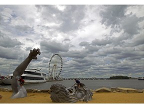 FILE - In this Sept. 3, 2016, file photo, children play on J. Seward Johnson's sculpture, "The Awakening," along the Potomac River waterfront at National Harbor, Md. Federal prosecutors say a man inspired by the Islamic State group stole a U-Haul truck with plans to drive it into a crowd at National Harbor, a convention and tourist destination just outside the nation's capital.