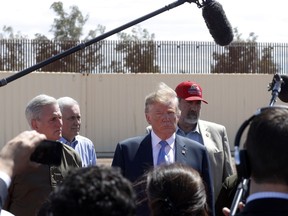 FILE - In this April 5, 2019, file photo, President Donald Trump visits a new section of the border wall with Mexico in Calexico, Calif. When Trump insisted last year that the border was in crisis, his warnings landed with a thud. Now, as the situation at the border has deteriorated to a level of alarm, Trump is again being met with skepticism, even as members on both sides of the aisle agree that there is a legitimate humanitarian emergency, with federal authorities and non-profits unable to cope with the influx of tens of thousands of Central American families seeking refuge in the U.S.