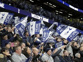 Tottenham fans wave flags on the stands before the start of the English Premier League soccer match between Tottenham Hotspur and Crystal Palace, the first Premiership match at the new Tottenham Hotspur stadium in London, Wednesday, April 3, 2019.