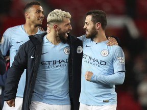 Manchester City's Sergio Aguero, center, and Manchester City's Bernardo Silva, right, celebrate at the end of the English Premier League soccer match between Manchester United and Manchester City at Old Trafford Stadium in Manchester, England, Wednesday April 24, 2019. Manchester City won 2-0.