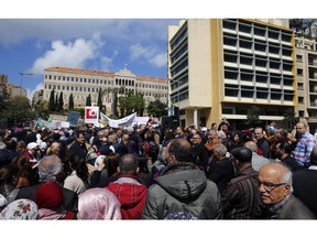 Civil servants protest in front of the government building during a parliament session to approve a plan to restructure the country's electricity sector, in Beirut, Lebanon, Wednesday, April 17, 2019. State employees fear they could have their salaries cut as the government discusses austerity measures to avoid a financial and economic crisis.