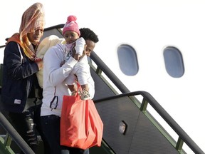 A family with a baby disembarks from an Italian military aircraft arriving from Misrata, Libya, at Pratica di Mare military airport, near Rome, Monday, April 29, 2019. Italy organized a humanitarian evacuation airlift for a group of 147 asylum seekers from Ethiopia, Eritrea, Somalia, Sudan and Syria.