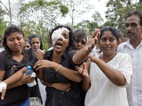 Anusha Kumari, second from left, weeps during a mass burial for her husband, two children and three siblings, all victims of Easter Sunday's bomb attacks, in Negombo, Sri Lanka, Wednesday, April 24, 2019. In an instant on Easter Sunday, Kumari, 43, was left childless and a widow when suicide bombers launched a coordinated attack on churches and luxury hotels in and just outside Sri Lanka's capital, Colombo.