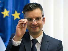 Slovenia's prime minister Marjan Sarec inspects his glasses during an interview with the Associated Press in Ljubljana, Slovenia, Tuesday, April 23, 2019.