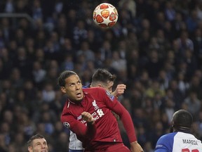 Liverpool's Virgil van Dijk, center, heads the ball the Champions League quarterfinals, 2nd leg, soccer match between FC Porto and Liverpool at the Dragao stadium in Porto, Portugal, Wednesday, April 17, 2019.