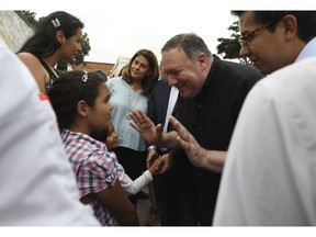 U.S. Secretary of State Mike Pompeo, right, greets a young Venezuelan migrant at a migrant shelter, as he's given a tour by Colombian Vice President Marta Lucia Ramirez, behind, and Colombian President Ivan Duque, not in picture, in La Parada near Cucuta, Colombia, on the border with Venezuela, Sunday, April 14, 2019. Pompeo is on a four-day Latin American tour, making his final stop at the Colombian border to meet with representatives of Venezuelan refugees.