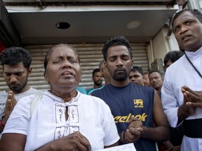 People pray during a nationwide three-minutes silence as a tribute to Easter Sunday attack victims in Colombo, Sri Lanka, Tuesday, April 23, 2019. Easter Sunday bombings of churches, luxury hotels and other sites was Sri Lanka's deadliest violence since a devastating civil war in the South Asian island nation ended a decade ago.