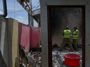 Police officers collect evidence from a site of a gun battle between troops and suspected Islamist militants in Kalmunai, Sri Lanka.