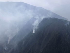 In this aerial photo released by Xinhua News Agency, smoke can be seen from a forest fire in Yalongjiang township of Muli County, Liangshan Yi Autonomous Prefecture in southwestern China's Sichuan Province on Monday, April 1, 2019. The fire high in the mountains of western China's Sichuan province has killed over two dozen firefighters and others, the government said Monday.