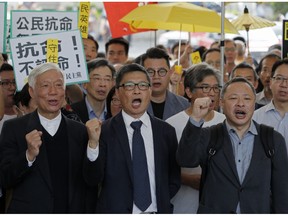 Occupy Central leaders, from right, Benny Tai, Chan Kin Man and Chu Yiu Ming shout slogans before entering a court in Hong Kong, Tuesday, April 9, 2019. Nine leaders of the 2014 Hong Kong pro-democracy movement hear the verdicts in their trial. The co-founders of the "Occupy Central" campaign - legal Professor Benny Tai Yiu-Ting, sociology professor Chan Kin-man and retired pastor Chu Yiu-ming - are facing charges related to the planning and implementation of the campaign which became part of the large-scale pro-democracy Umbrella Movement protests which were carried out 79 days between September and December 2014.