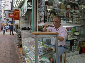 In this April 18, 2019, photo, Cheung Shun-king, 65-year-old maker of the popular table-top game mahjong tiles, engraves a character on a tile in his decades-old store in Kowloon's old neighborhood of Hong Kong. Hand-carved mahjong tiles is a dying art in Hong Kong.