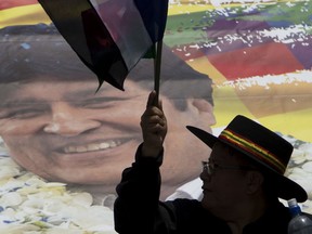 FILE - In this Nov. 7, 2017 file photo, a supporter of Bolivia's President Evo Morales waves a party flag during a march supporting his re-election, despite a referendum ruling out his run for a fourth term, in La Paz, Bolivia. The prominent human rights group Human Rights Watch says Bolivia has undermined judicial independence by arbitrarily dismissing nearly 100 judges since 2017 and it's asking the Organization of American States to address the issue. HRW says the judges haven't been given any reason for the dismissals by a Magistrates Council dominated by Morales' allies.