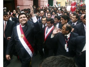 FILE - In this July 28, 2006 file photo, Peruvian President Alan García waves to a crowd after his swearing-in ceremony while he walks through the streets of Lima, Peru. Current President Martinez Vizcarra said Garcia, the 69-year-old former head of state died Wednesday, April 17, 2019, after undergoing emergency surgery in Lima. Garcia shot himself in the head early Wednesday as police came to detain him in connection with a corruption probe.