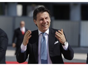 Italian Premier Giuseppe Conte gestures as he attends the unveiling of the Generali tower skyscraper, designed by architect and designer Zaha Hadid, in Milan, Italy, Tuesday, April 9, 2019.