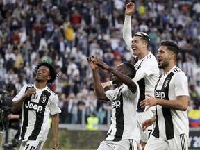 From left, Juventus' Juan Cuadrado, Cristiano Ronaldo, Blaise Matuidi and Emre Can celebrate at the end of a Serie A soccer match between Juventus and AC Fiorentina, at the Allianz stadium in Turin, Italy, Saturday, April 20, 2019. Juventus clinched a record-extending eighth successive Serie A title, with five matches to spare, after it defeated Fiorentina 2-1.