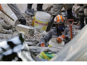 Firefighters try to find survivors amid the debris of two buildings that collapsed in Muzema neighborhood in Rio de Janeiro, Brazil, Saturday, April 13, 2019, one day after two buildings collapsed leaving at least seven victims and seventeen people missing, according the authorities.