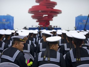 Chinese sailors sit during a concert featuring Chinese and foreign military bands in Qingdao, Monday, April 22, 2019. Ships from Chinese and foreign navies have gathered in Qingdao for events this week, including a naval parade, to mark the 70th anniversary of the founding of the People's Liberation Army (PLA) Navy.