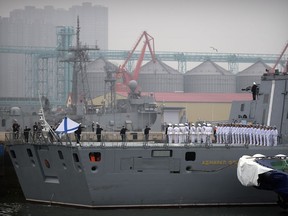 In this April 21, 2019, photo, Russian sailors stand on the deck of the Russian frigate Admiral Gorshkov as it docks at a port in Qingdao in eastern China's Shandong Province. Chinese Defense Ministry spokesman Ren Guoqiang said Thursday, April 25, 2019, that naval drills between China and Russia will be held off the eastern port city of Qingdao next week.