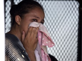 A Guatemalan migrant cries after being taken into custody by Mexican immigration agents, as she sits in an immigration vehicle after her journey to the US-Mexico border came to a stop, near Santo Domingo Zanatepec, Oaxaca state, Mexico, Wednesday, April 24, 2019. Throngs of police pickups and small immigration vans are parked at checkpoints up and down the narrow waist of southern Mexico, making it difficult for migrants who are hitchhiking, taking buses or walking.