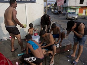 Central American migrants, part of a caravan hoping to reach the U.S. border, take a shower at a makeshift camp set up in Escuintla, Chiapas State, Mexico, Friday, April 19, 2019. Thousands of migrants in several different caravans have been gathering in Chiapas in recent days and weeks.