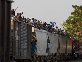 Central American migrants ride atop a freight train during their journey toward the U.S.-Mexico border, in Ixtepec, Oaxaca State, Mexico, Tuesday, April 23, 2019.