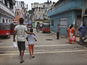 A Sri Lankan Catholic Christian father and son return to their home from a market in Colombo, Sri Lanka, Monday, April 29, 2019. The Catholic Church in Sri Lanka says the government should crack down on Islamic extremists with more vigor "as if on war footing" in the aftermath of the Easter bombings.