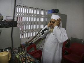 A Sri Lankan Muslim priest calls for Friday prayers from a mosque, in Colombo, Sri Lanka, Friday, April 26, 2019. Across Colombo, there was a visible increase of security as authorities warned of another attack and pursued suspects that could have access to explosives. Authorities had told Muslims to pray at home rather than attend communal Friday prayers that are the most important religious service for the faithful. At one mosque in Colombo where prayers were still held, police armed with Kalashnikov assault rifles stood guard outside.