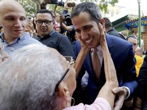 Juan Guaido, Venezuelan opposition leader and self-proclaimed interim president, is greeted by a supporter as he leaves a meeting at a university in Caracas, Venezuela, Monday, April 1, 2019. He's backed by more than 50 nations, which consider Nicolas Maduro's presidency illegitimate following what they call sham elections last year. "We must unite now more than ever," said Guaido, speaking at the university. "We must mount the biggest demonstration so far to reject what's happening."