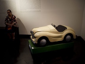 A visitor sits near a toy pedal car of the "Childhood and Peronism, the toys of the Eva Perón Foundation" exhibit at the Evita Museum in Buenos Aires, Argentina, Wednesday, April 17, 2019. To mark the 100th anniversary of the birth of Argentina's so-called "champion of the poor" on May 7, 1919, the Evita Museum in Buenos Aires has inaugurated the exhibit, which displays several dozen of the toys distributed by the party on Christmas Day and the holiday of Epiphany between 1948 and 1955.