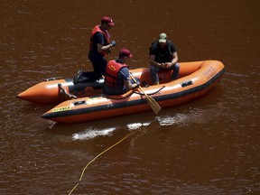 Members of the Cyprus Special Disaster Response Unit search for a suitcase in a man-made lake, near the village of Mitsero outside of the capital Nicosia, Cyprus, Monday April 29, 2019. Cyprus' Fire Service chief says poor visibility in the toxic waters of a man-made lake is hampering a search for a suitcase believed to contain human remains, one of seven foreign women and girls that a Cypriot military officer has confessed to killing.