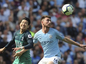 Manchester City's Aymeric Laporte, right, fights for the ball with Tottenham's Heung-Min Son during the English Premier League soccer match between Manchester City and Tottenham Hotspur at Etihad stadium in Manchester, England, Saturday, April 20, 2019.